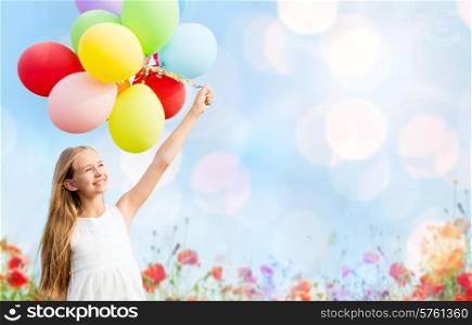 summer holidays, celebration, children and people concept - happy girl with colorful balloons over blue lights and poppy field background