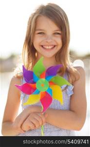 summer holidays, celebration, family, children and people concept - happy girl with colorful pinwheel toy