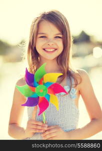 summer holidays, celebration, family, children and people concept - happy girl with colorful pinwheel toy