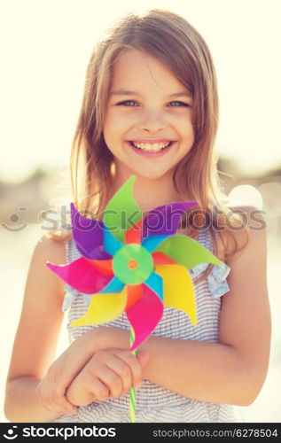 summer holidays, celebration, family, children and people concept - happy girl with colorful pinwheel toy