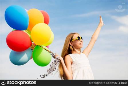 summer holidays, childhood and people concept - happy girl in sunglasses with air balloons outdoors. happy girl in sunglasses with air balloons