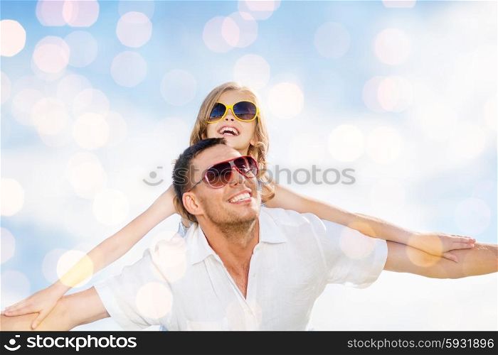 summer holidays, children and people concept - happy father and child in sunglasses over blue lights background