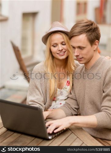 summer holidays, city, dating and technology concept - couple with laptop in cafe