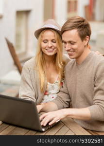 summer holidays, city, dating and technology concept - couple with laptop in cafe