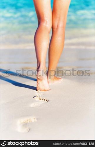 Summer holidays concept, closeup photo of a sexy womans legs, slim female walking on the beach, carefree lifestyle, summer vacation background, relaxation and life joy