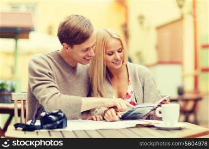 summer holidays, dating and tourism concept - couple with map, camera, travellers guide and coffee in cafe