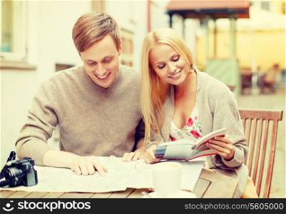 summer holidays, dating and tourism concept - couple with map, camera, travellers guide and coffee in cafe