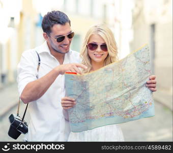 summer holidays, dating and tourism concept - smiling couple in sunglasses with map in the city