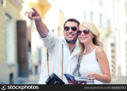 summer holidays, dating, city break and tourism concept - couple with camera and travellers guide