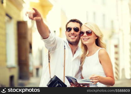 summer holidays, dating, city break and tourism concept - couple with camera and travellers guide