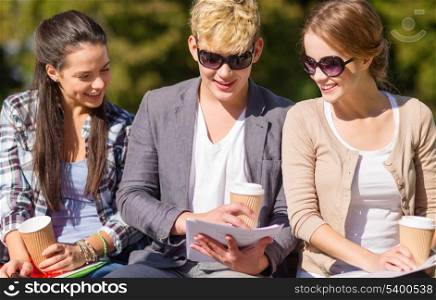 summer holidays, education, campus and teenage concept - group of students or teenagers with books, notebooks, files and folders