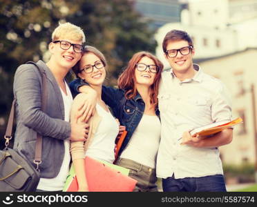 summer holidays, education, campus and teenage concept - group of students or teenagers with files, folders and eyeglasses hanging out