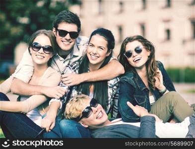 summer holidays, education, campus and teenage concept - group of students or teenagers hanging out