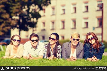 summer holidays, education, campus and teenage concept - group of students or teenagers hanging out