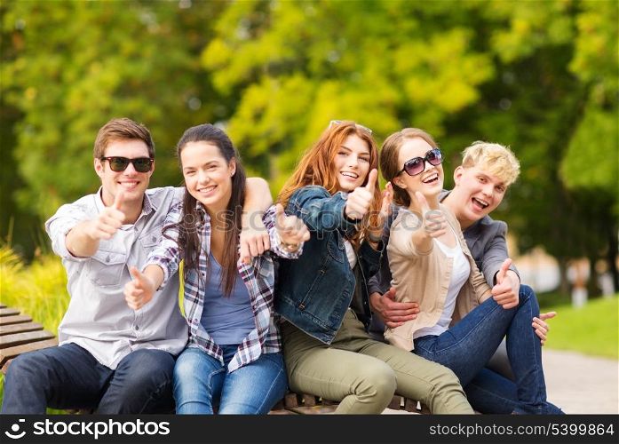 summer holidays, education, campus and teenage concept - group of students or teenagers showing thumbs up
