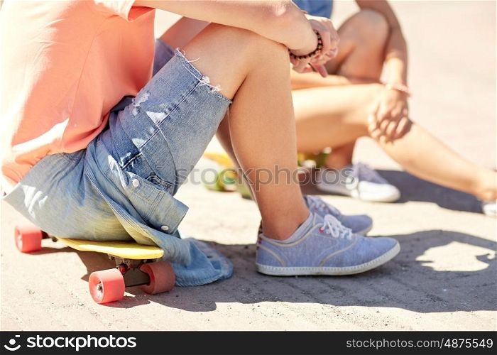 summer holidays, extreme sport and people concept - close up of teenage couple with short modern cruiser skateboards on city street