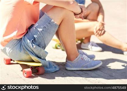 summer holidays, extreme sport and people concept - close up of teenage couple with short modern cruiser skateboards on city street