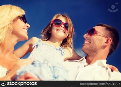 summer holidays, family, child and people concept - happy family in sunglasses over blue sky