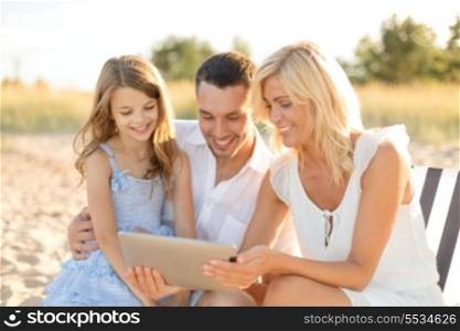 summer holidays, family, child and technology concept - smiling family at beach with tablet pc computer