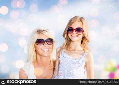 summer holidays, family, children and people concept - mother and child in sunglasses over blue lights background