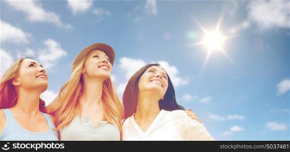 summer holidays, friendship and people concept - group of happy smiling women or friends over sky and sun background. group of happy smiling women or friends over sky