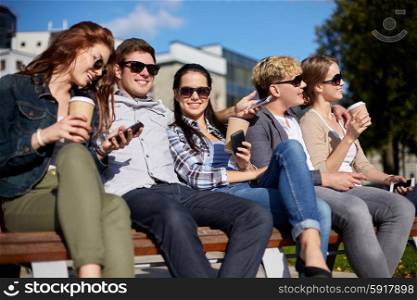 summer holidays, friendship, leisure and teenage concept - group of happy students or teenagers hanging out and drinking coffee at campus or park