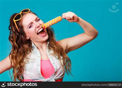 Summer holidays happiness concept. Happy joyful and cheerful young woman female model eating popsicle ice pop on blue background