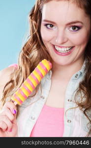 Summer holidays happiness concept. Happy joyful and cheerful young woman female model eating popsicle ice pop on blue background