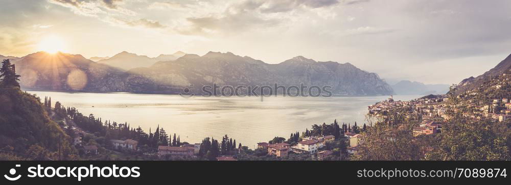 Summer holidays in the Dolomites: Idyllic coastline at lago di garda with cute little village Malcesine. Panorama.