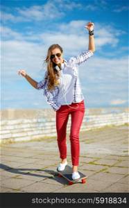summer holidays, leisure and teenage concept - smiling teenage girl in sunglasses riding skate outside