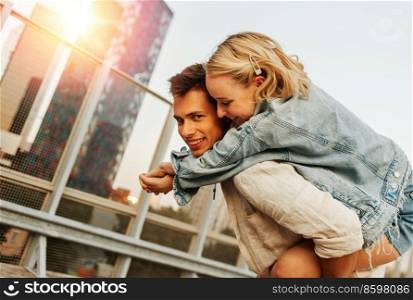 summer holidays, love and people concept - happy young couple having fun on roof top parking. happy young couple having fun on roof top parking