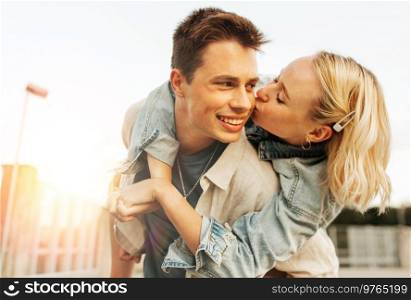 summer holidays, love and people concept - happy young couple kissing and hugging on roof top. happy young couple kissing and hugging on roof top