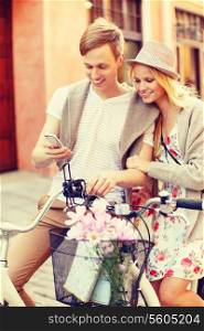 summer holidays, love, navigation, gps and dating concept - couple with bicycles and smartphone in the city