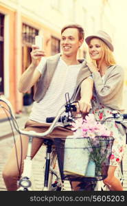 summer holidays, love, navigation, gps and dating concept - smiling couple with bicycles and smartphone in the city