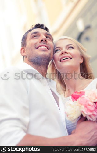 summer holidays, love, relationship and dating concept - couple with bouquet of flowers in the city