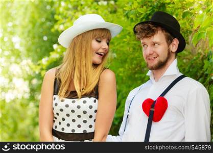 Summer holidays love relationship and dating concept - romantic happy couple retro style with red heart love symbol outdoor
