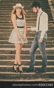Summer holidays love relationship and dating concept - romantic playful couple retro style flirting on city stairs