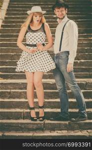 Summer holidays love relationship and dating concept - romantic playful couple retro style flirting on city stairs
