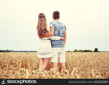 summer holidays, love, romance and people concept - happy smiling young hippie couple hugging outdoors from back
