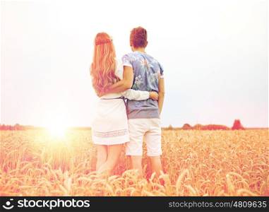 summer holidays, love, romance and people concept - happy smiling young hippie couple hugging outdoors from back
