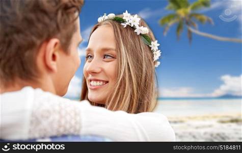 summer holidays, love, romance and people concept - happy smiling young hippie couple hugging over tropical beach background. happy smiling young hippie couple on summer beach