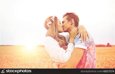 summer holidays, love, romance and people concept - happy young hippie couple kissing outdoors