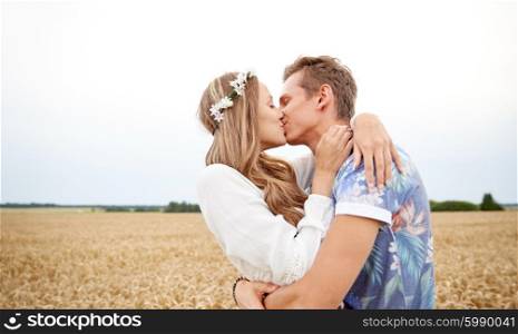 summer holidays, love, romance and people concept - happy young hippie couple kissing outdoors
