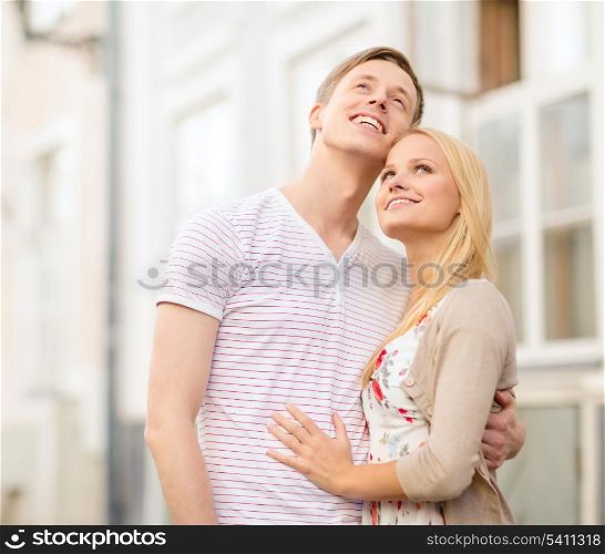 summer holidays, love, travel, tourism, relationship and dating concept - romantic couple in the city looking up