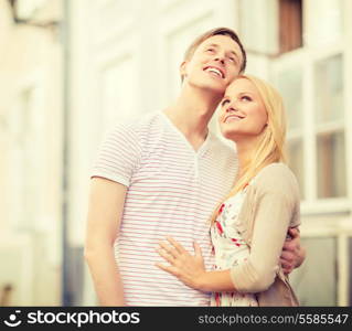 summer holidays, love, travel, tourism, relationship and dating concept - romantic couple in the city looking up