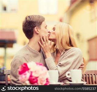 summer holidays, love, travel, tourism, relationship and dating concept - romantic happy couple kissing in the cafe