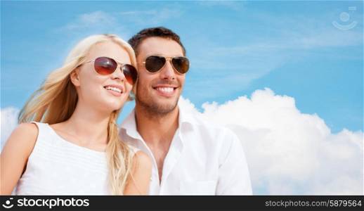 summer holidays, people and dating concept - happy couple in shades over blue sky and white cloud background