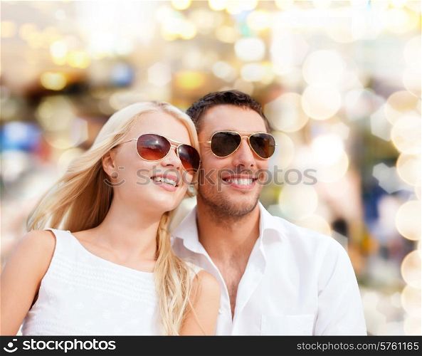 summer holidays, people and dating concept - happy couple in shades over lights background