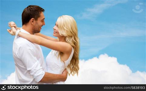 summer holidays, people, love and dating concept - happy couple hugging over cloud and blue sky background
