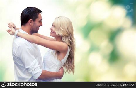 summer holidays, people, love and dating concept - happy couple hugging over green background